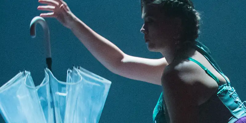 A scene from Burlesque showing Betty doing a dance holding a sun umbrella