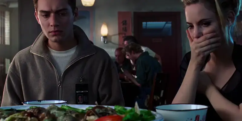 A scene in eXistenZ showing Ted and Allegra looking startled at the contents of a dish laid on the table before them