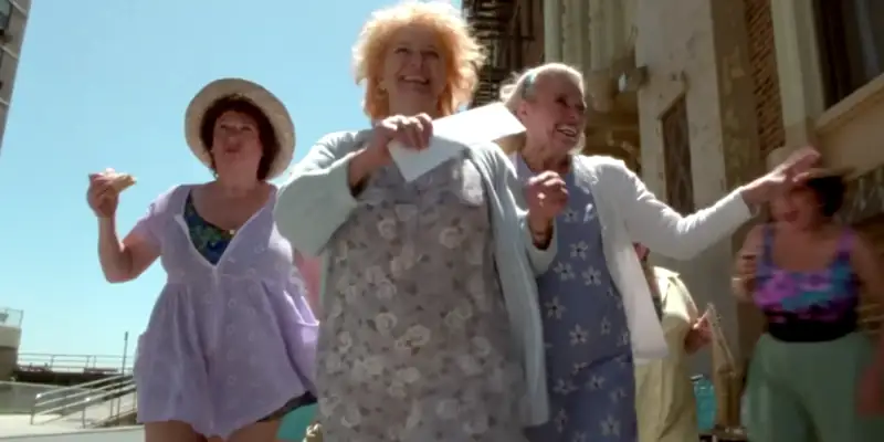 A scene from Requiem for a Dream showing Sara and her friends walking triumphantly down a sunny street