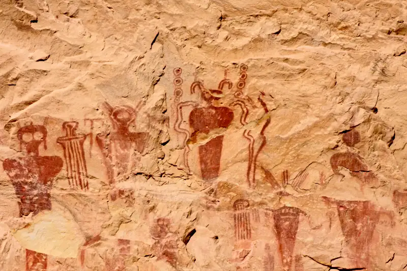 Petroglyphs in red found in Sego Canyon, USA, showing red ochre coloured images of humanoid figures with filamentous horns and goggle-eyes.
